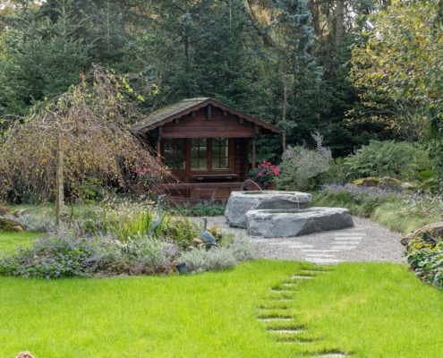 Gartenparadies mit wunderschöner Bepflanzung und Steinbrunnen